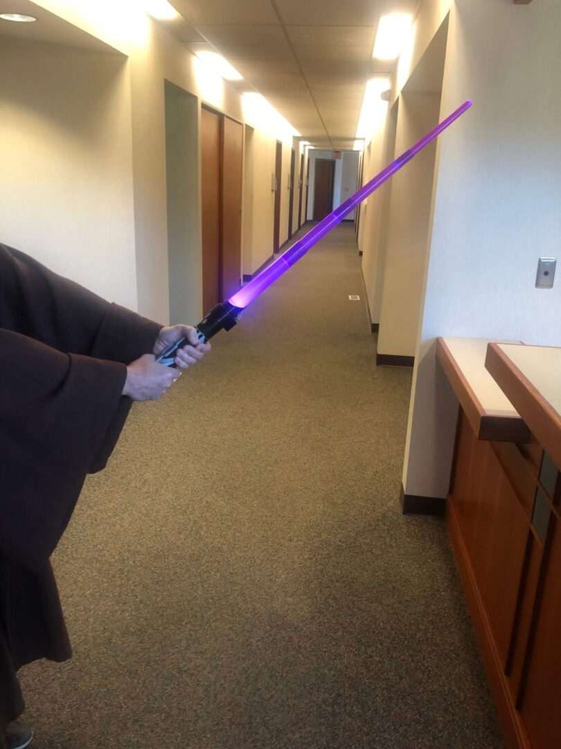 A person holding a toy lightsaber