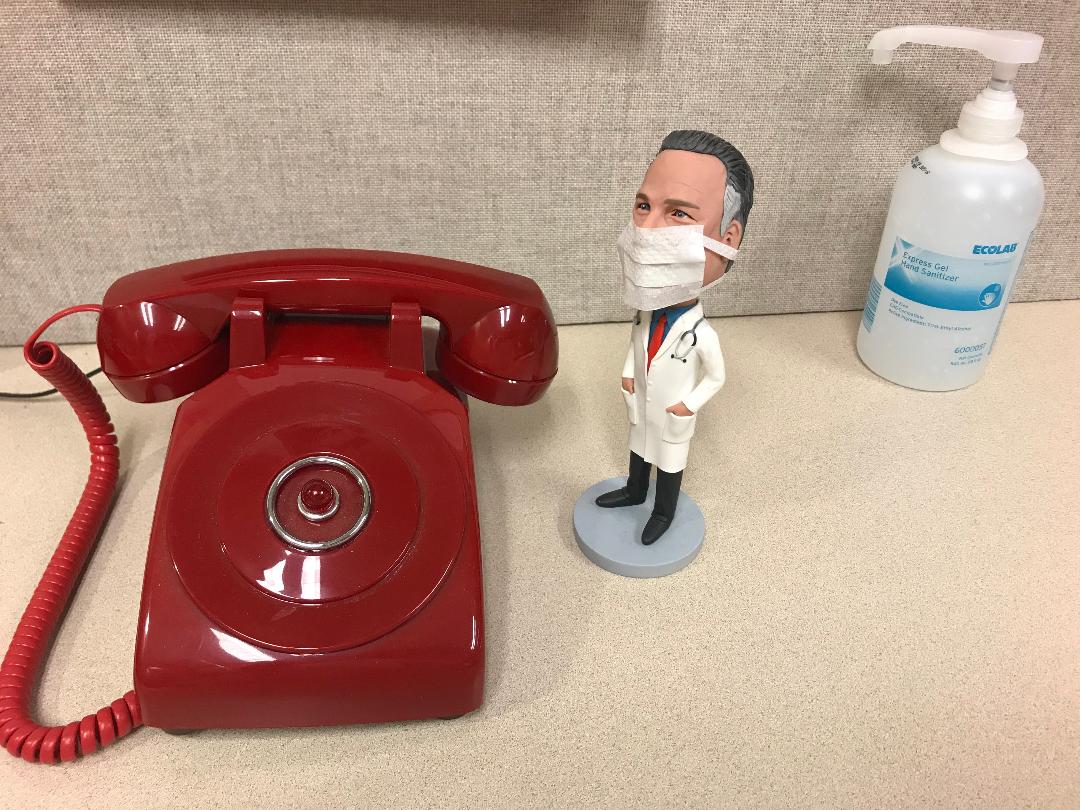 A Hand Sanitizer, Toy with Mask, and a Wired Telephone