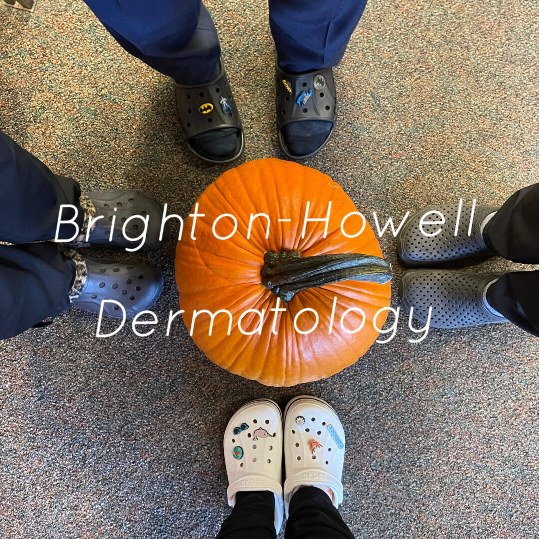A shot of four people’s feet and a big pumpkin