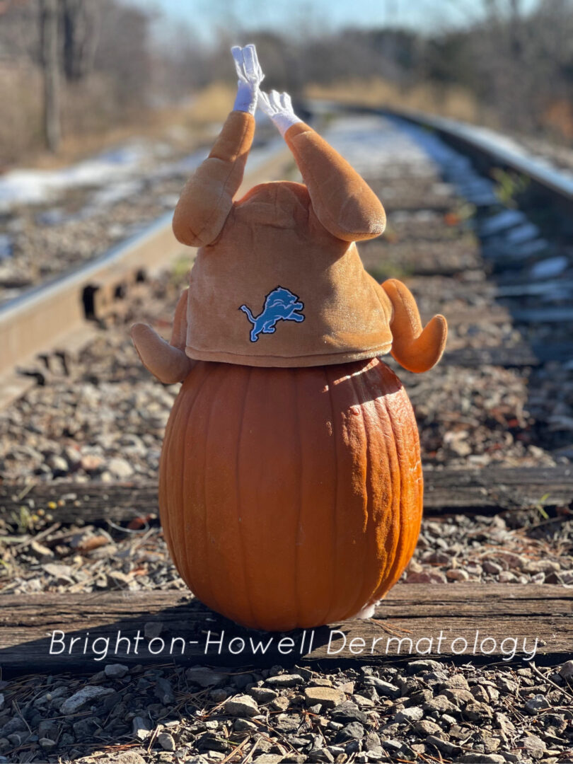 A turkey toy and pumpkin with the text “Brighton-Howell Dermatology”